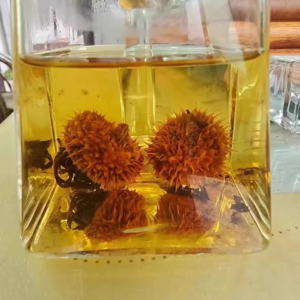 A top-down customer review photo of a clear glass filled with brewed Chestnut Rose tea, showing its bright golden-yellow color and clarity.