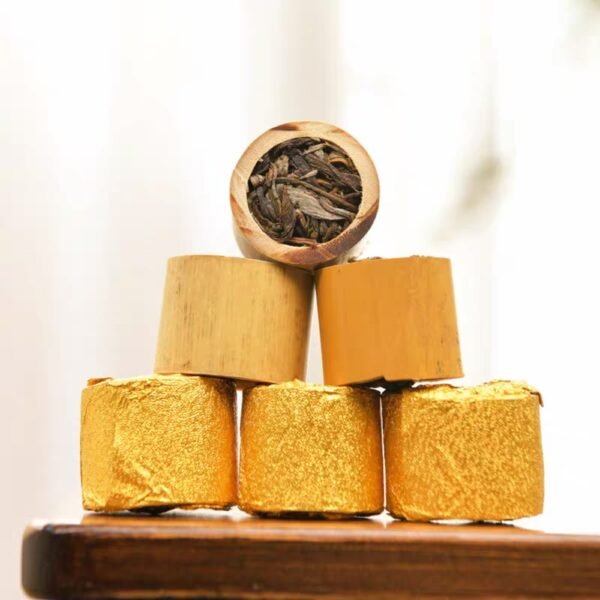 Premium raw Pu-erh tea pressed into a natural bamboo tube, wrapped in artisanal gold foil for aging and gifting.