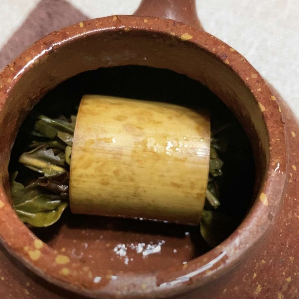 A customer's photo showing Bamboo Dew Pu'er tea steeping perfectly inside a traditional rustic clay teapot.