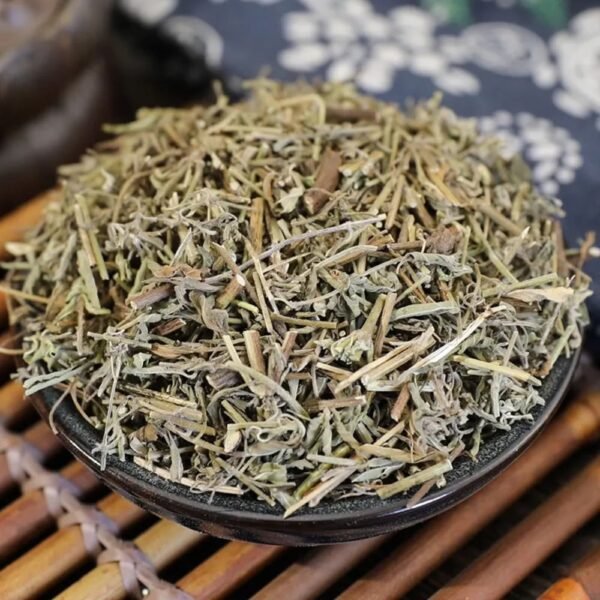 A close-up of premium, dried Xiangru sprig stems and leaves resting in a dark ceramic bowl on a traditional bamboo mat.