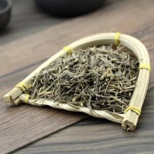 A rustic bamboo scoop holding dried, pure Xiangru sprigs on a wooden table, highlighting the fresh and clean herbal ingredients for brewing.
