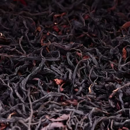 Macro texture shot of Dianhong black tea leaves from Fengqing, Yunnan. Selected for its full aroma and clear sweetness to serve as the tea base.